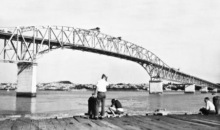 Fishing from Northcote Wharf with a view of the new (but not complete) Auckland Harbour Bridge. Opened May 30, 1959. "Clip-on" lanes added 1969.